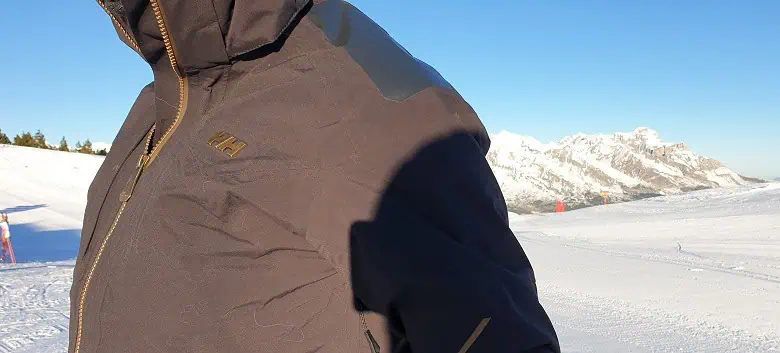 Gros plan sur la l'anorak de ski Atlas Infinity pendant une journée ensoleillée en station
