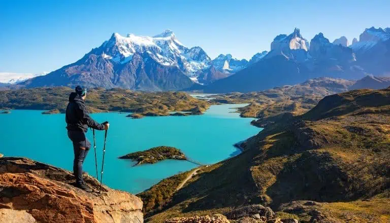 randonneur devant un lac aux eaux turquoises
