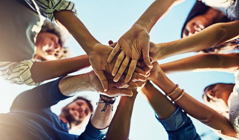 Illustration de l'esprit d'équipe : groupe de personne tendant la main