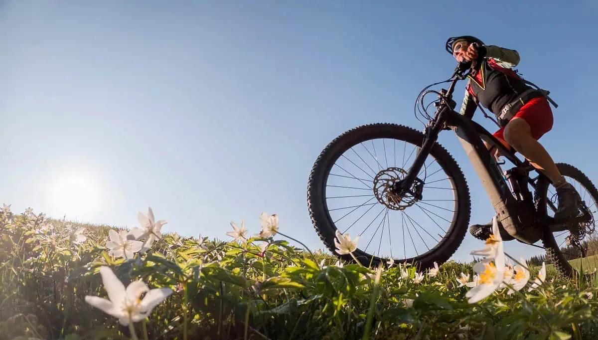 femme faisant du VTT électrique dans les champs, vue en contreplongée