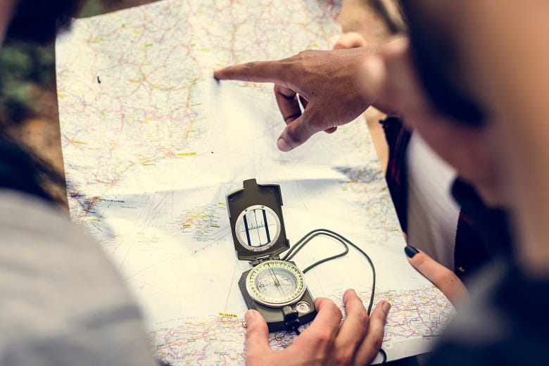 Randonneurs se repréant sur une carte à l'aide d'une boussole