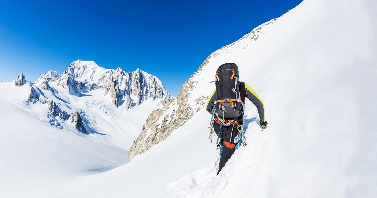alpiniste grimpant dans la neige pendant une ascension hivernale