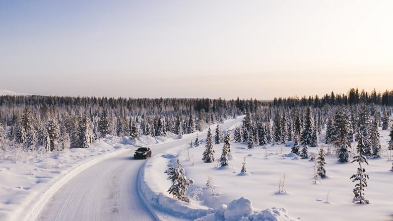 vue aérienne d'une voiture sur une route enneigée déserte