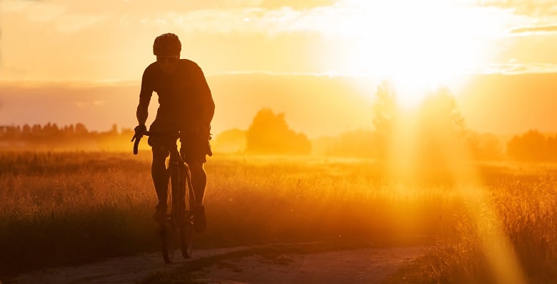 silhouette d'un homme sur son gravel bike au coucher de soleil