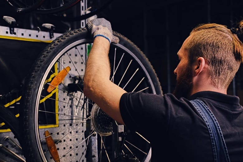 mecanicien vélo montant un pneu VTT