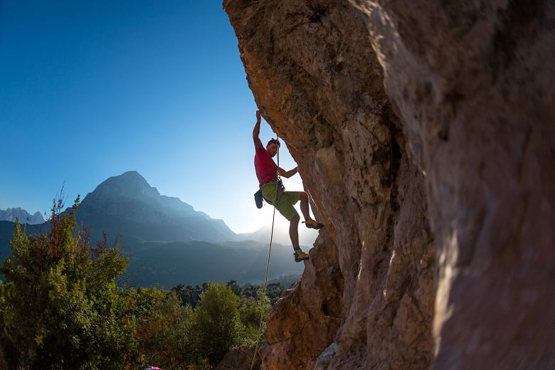 grimpeur pratiquant l'escalade sur une falaise aménagée