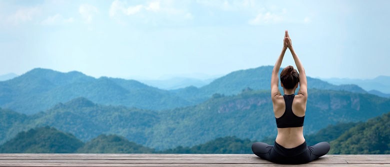 jeune femme en plaine forme pratiquant le yoga dans la nature