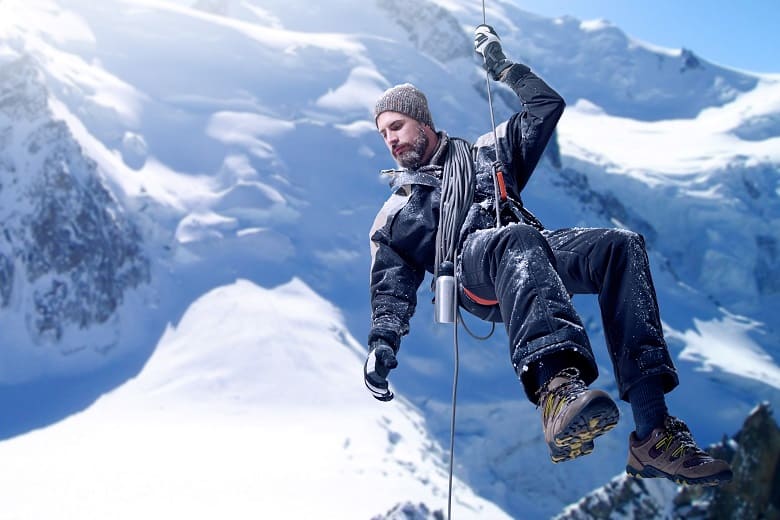 sauveteur descendant en rappel dans les alpes en hiver